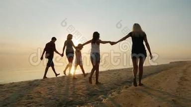 孩子们和成年人的陪伴在海滩上玩得很开心，牵着手。